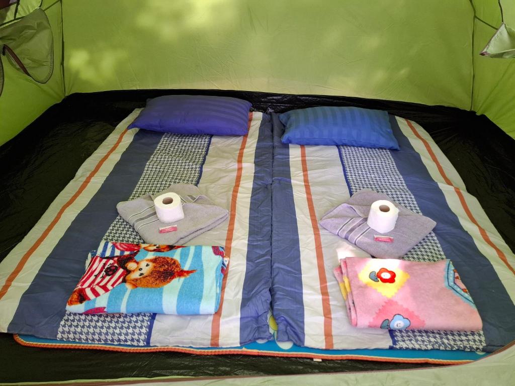 班泰双石旅馆的床上配有毛巾和卫生间