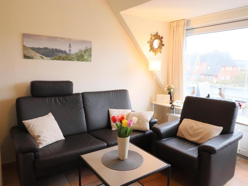 文尼斯塔特3-Zimmer Appartement in Wenningstedt in ruhiger Lage的客厅配有沙发和鲜花桌