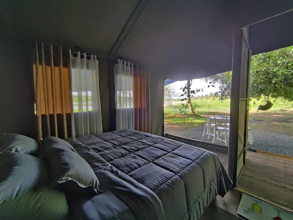 达瓦拉维Harmony Haven Eco Camp, Udawalawa的一间卧室设有一张大床和一个大窗户