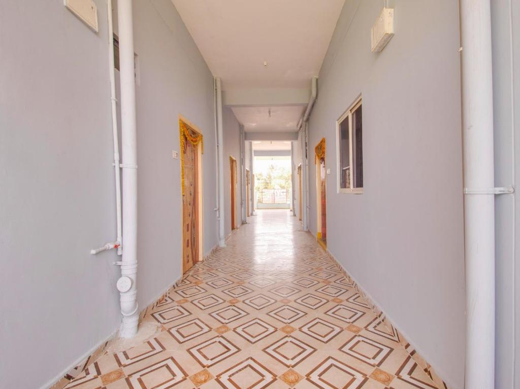 PargiG7 Residency的一条空的走廊,铺着瓷砖地板,墙壁白色