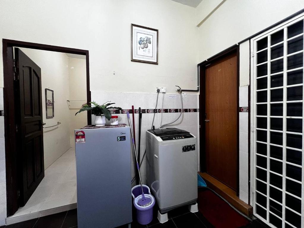 瓜拉丁加奴Dhiaa Homestay D Jembal的一间设有小冰箱和门的房间