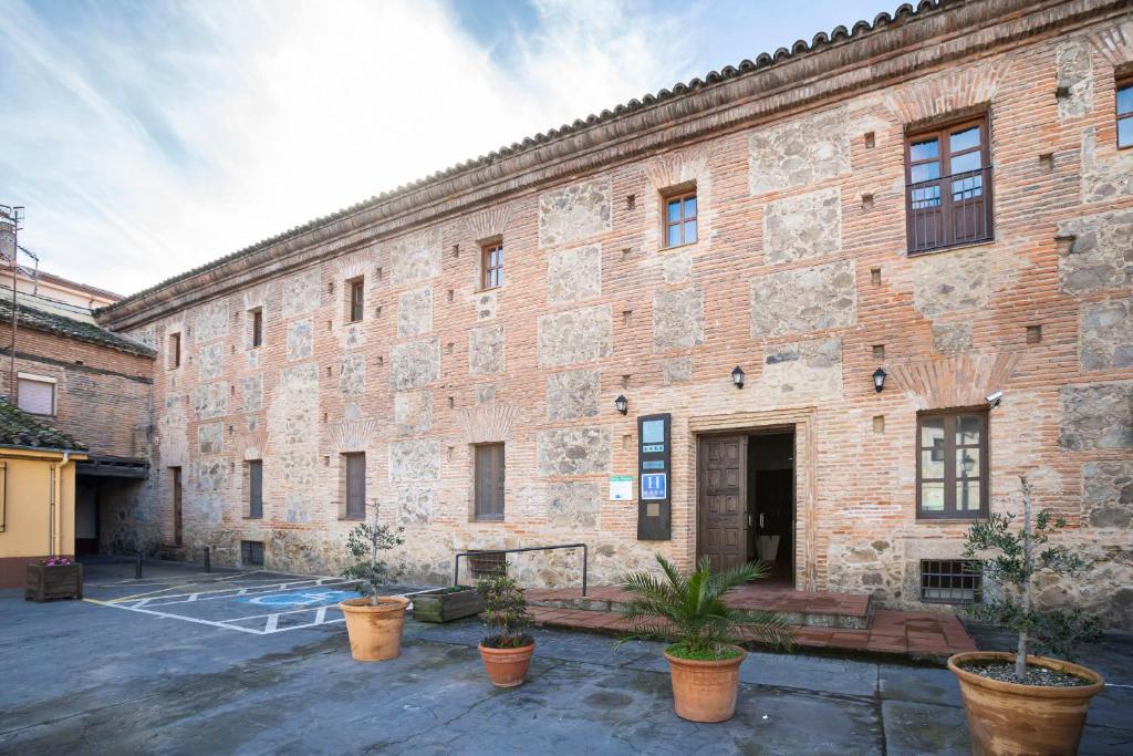 埃尔瓦安布罗兹山谷酒店的庭院中一座种植了盆栽植物的大型砖砌建筑