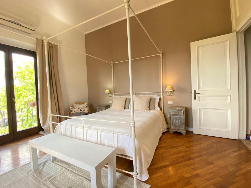 格罗塔费拉塔“Casa Amélie”的卧室配有一张白色的天蓬床和桌子