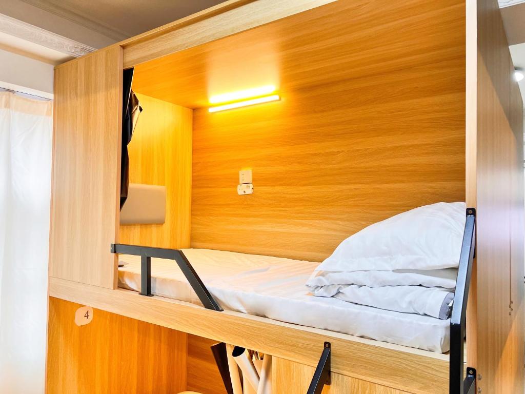 香港Waveflo Hostel 浪花青旅的一张小床,位于带木墙的小房间