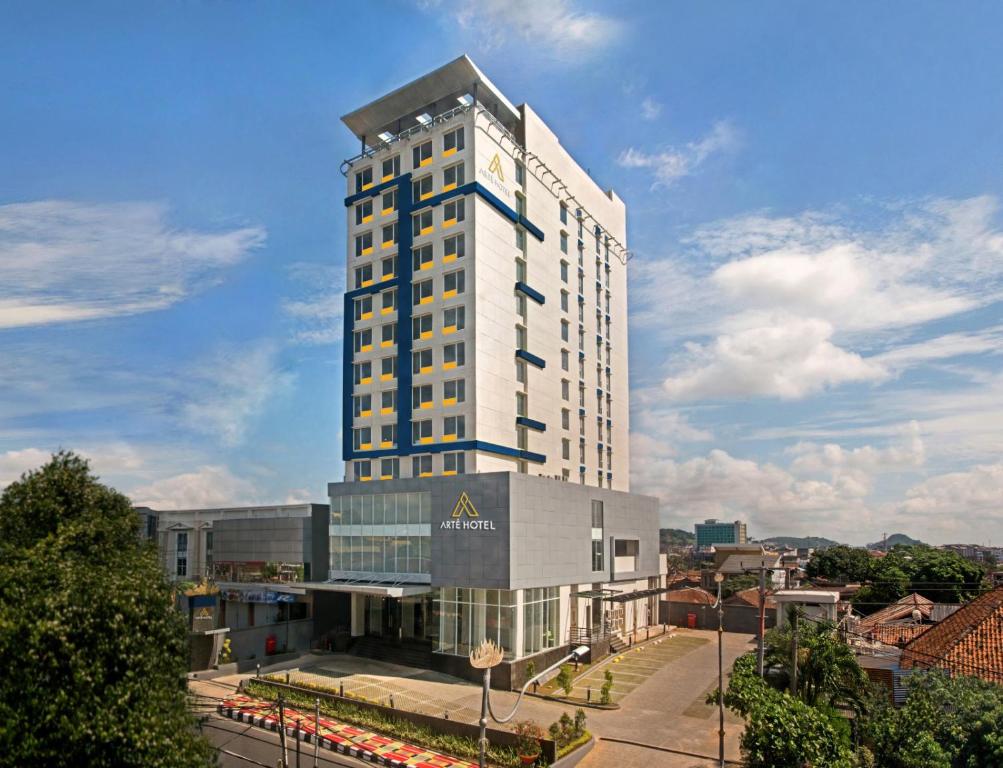 班达楠榜Arte Hotel Bandar Lampung的一座高大的白色建筑,上面有时钟