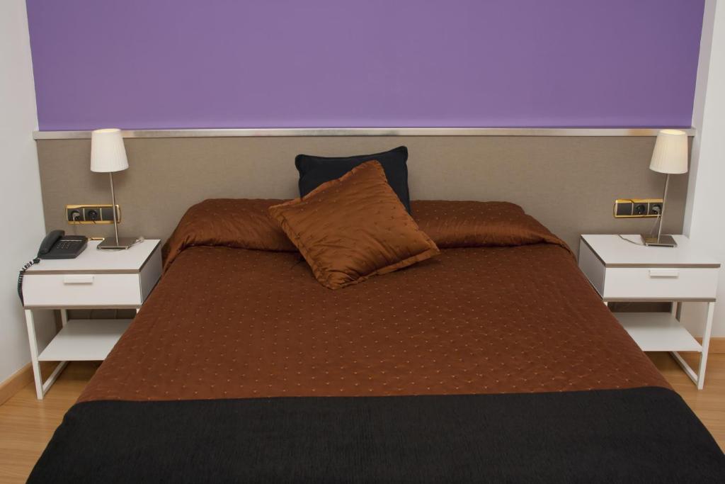 巴塞罗那阿伯特酒店的一间卧室,配有带2个床头柜的床