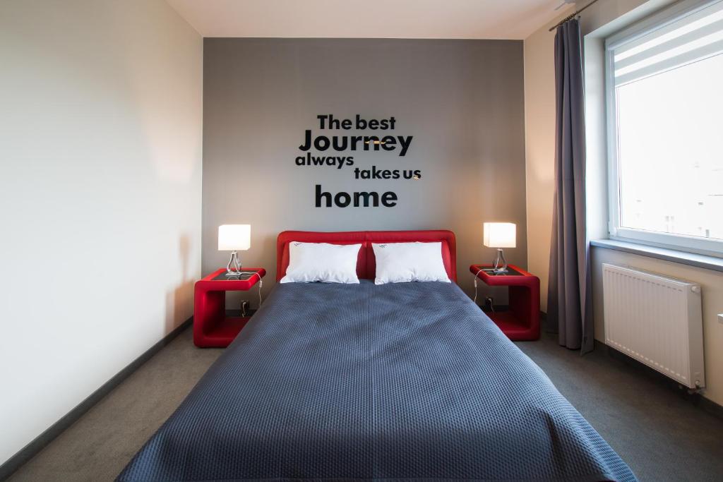 罗兹维哥酒店的一间卧室配有床和两张红色的桌子