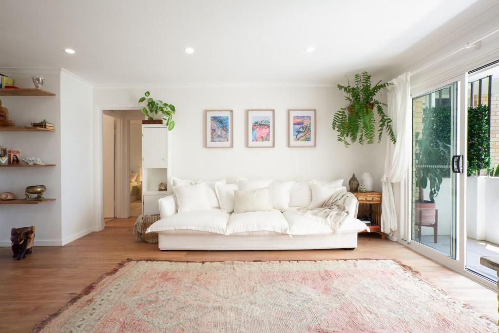 悉尼La Brisa Coogee的客厅配有白色沙发和地毯。