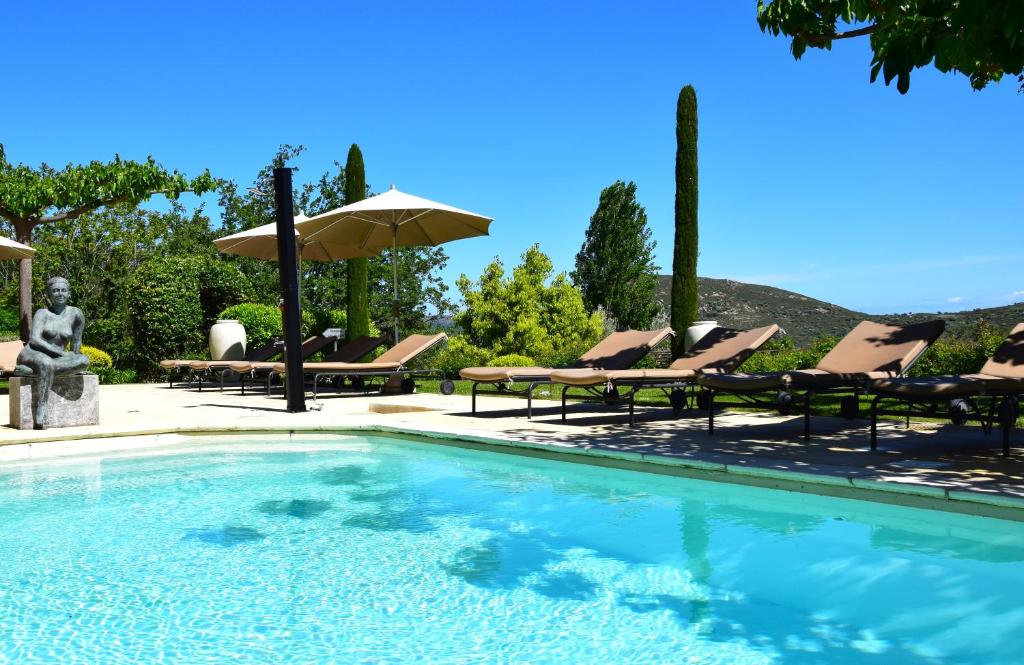 费里切托卡斯安娜利迪娅 - 魅力酒店的一个带躺椅和遮阳伞的游泳池