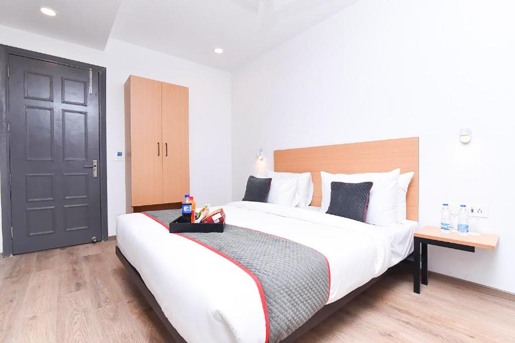 新德里Hotel Rudra的一间卧室设有一张大床和一扇黑色的门