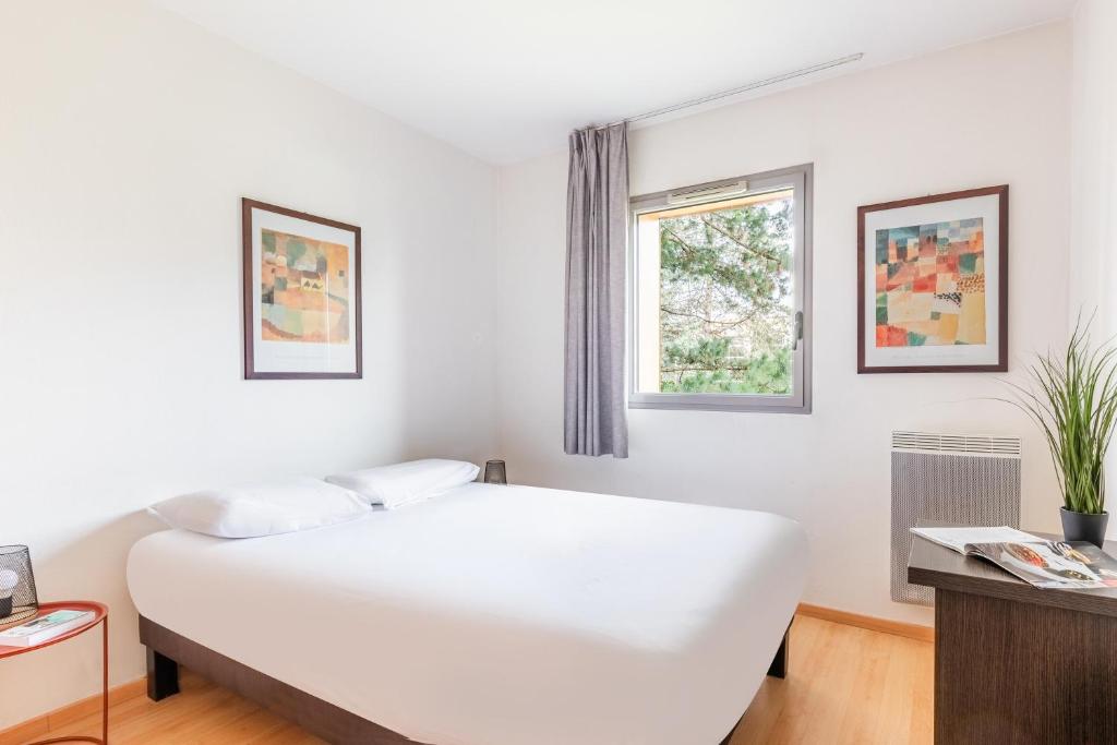 卡尔克富Appart'City Classic Nantes - Carquefou的白色的卧室设有床和窗户