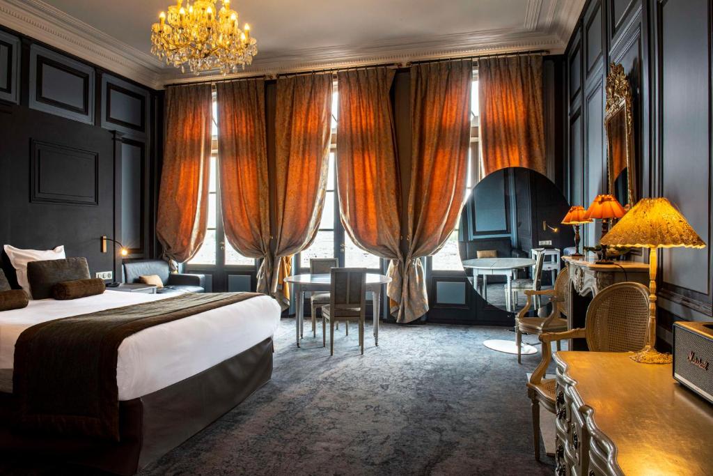 翁弗勒尔Best Western Le Cheval Blanc -Vue sur le port-plein centre ville的酒店客房配有一张床、一张书桌和一张书桌。