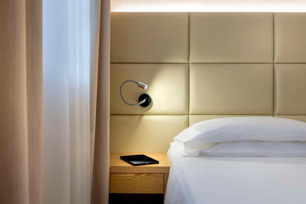 卡尔达诺阿尔坎波贝斯特韦斯特卡瓦利瑞德拉科洛纳酒店的一间卧室配有一张带床头板和灯的床
