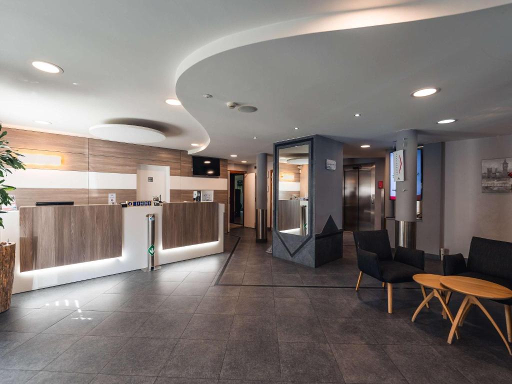 沙勒罗瓦Ibis Styles Charleroi Airport Aero 44的办公室的大堂,配有桌椅