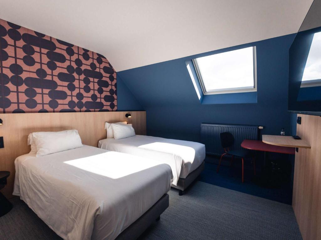 沙勒罗瓦Aero44 Hotel Charleroi Airport的酒店客房配有两张床和一张书桌