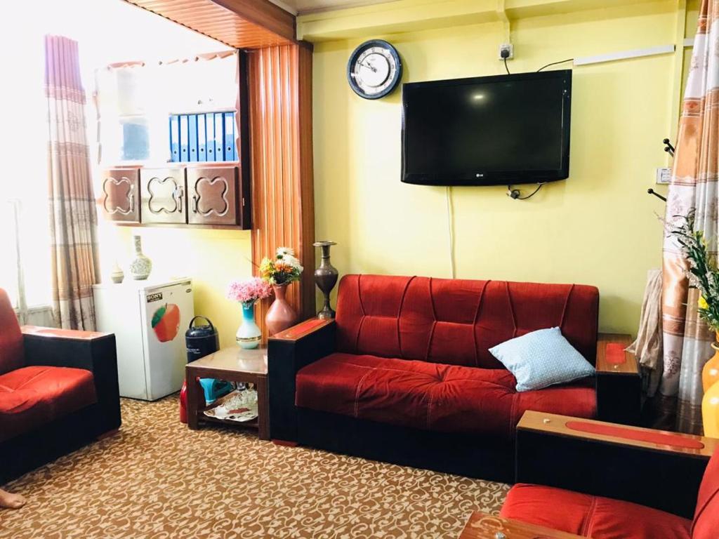 坎大哈Millat Hotel & Noor Jahan Hotel Kandahar的客厅配有红色沙发和电视