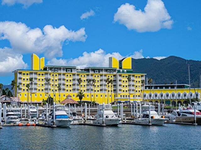 和歌山和歌山港酒店的码头上停有船只的黄色酒店