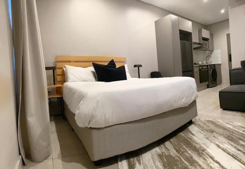 约翰内斯堡Blackbrick Sandton two no-loadshedding的卧室配有一张带白色床单和枕头的大床。