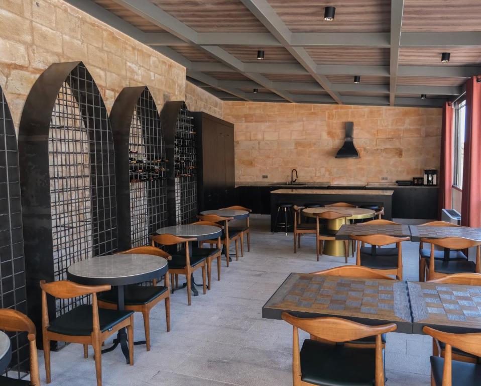 马尔丁Mirsoum Han的一间带木桌椅的餐厅和一间酒吧