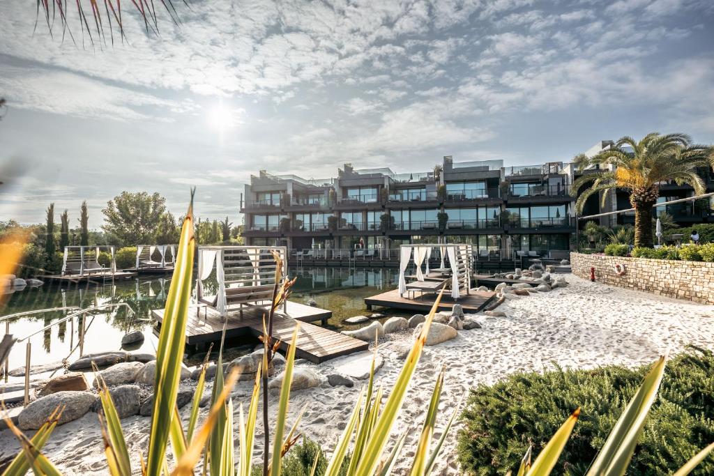 拉齐塞Quellenhof Luxury Resort Lazise的一个带椅子和水体的度假胜地