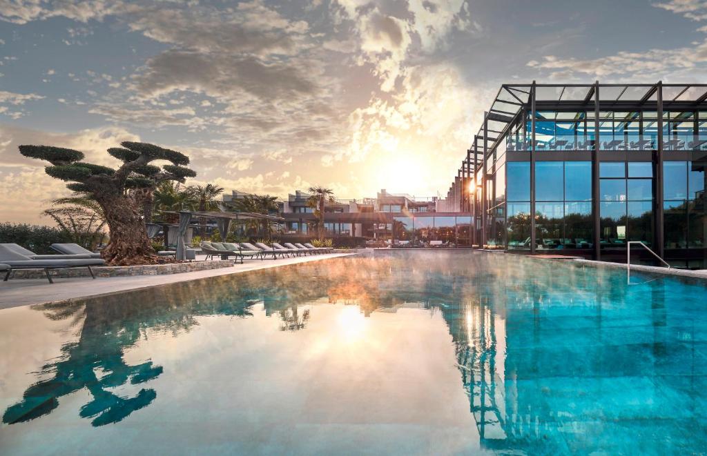 拉齐塞Quellenhof Luxury Resort Lazise的大楼前的大型游泳池