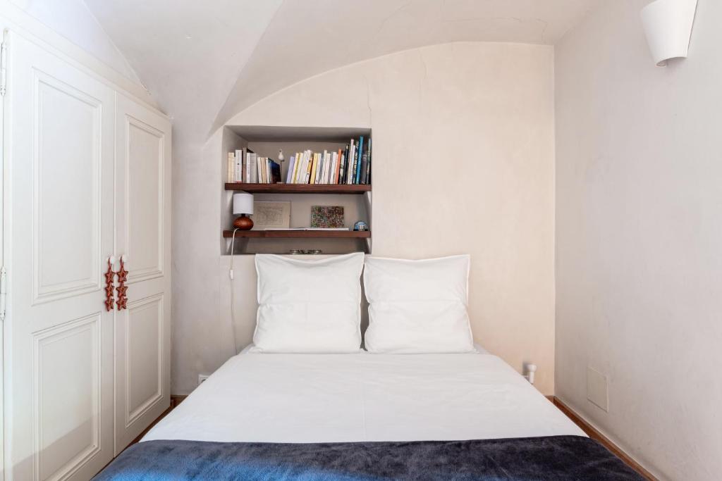 圣莫里斯堡镇中心住宿加早餐旅馆 的一间卧室配有白色床单和书架。