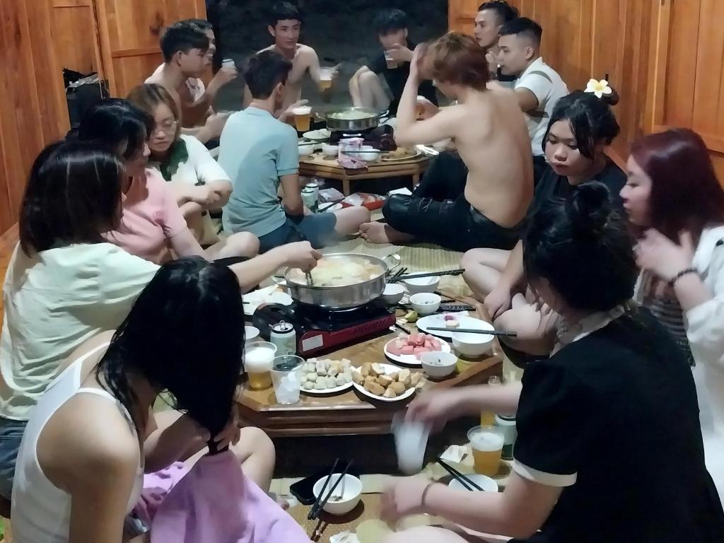 高平Trieu Hoan homestay的一群坐在桌子旁吃食物的人