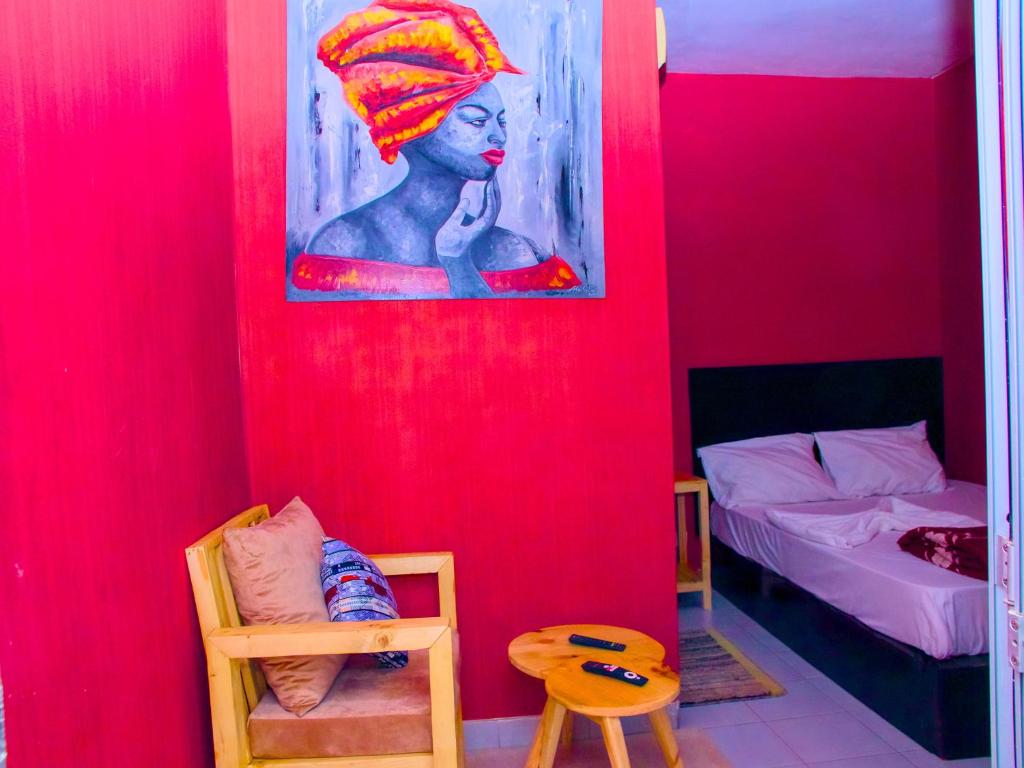 达喀尔达喀尔国际旅舍的一间有红色墙壁的房间,上面有一幅画女画