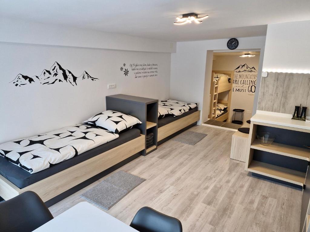 莫斯特拉纳Apartma Vovk的一间设有两张床和一张桌子及椅子的房间