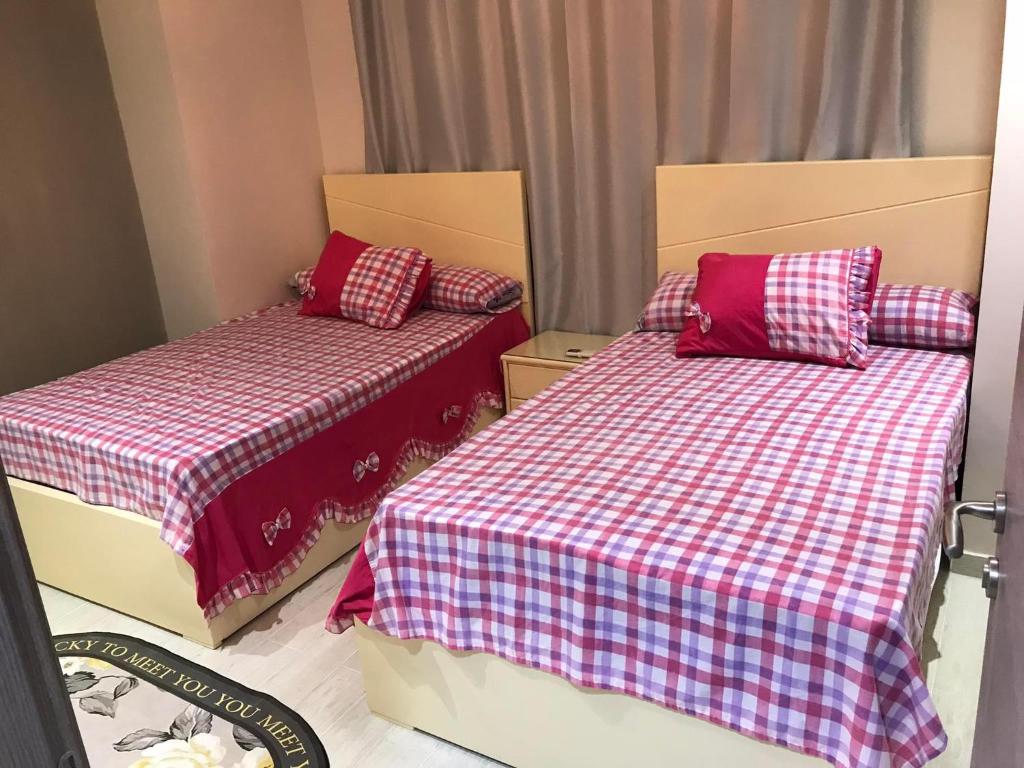 艾因苏赫纳Ilmontegalala的一间卧室配有两张红色和白色床单