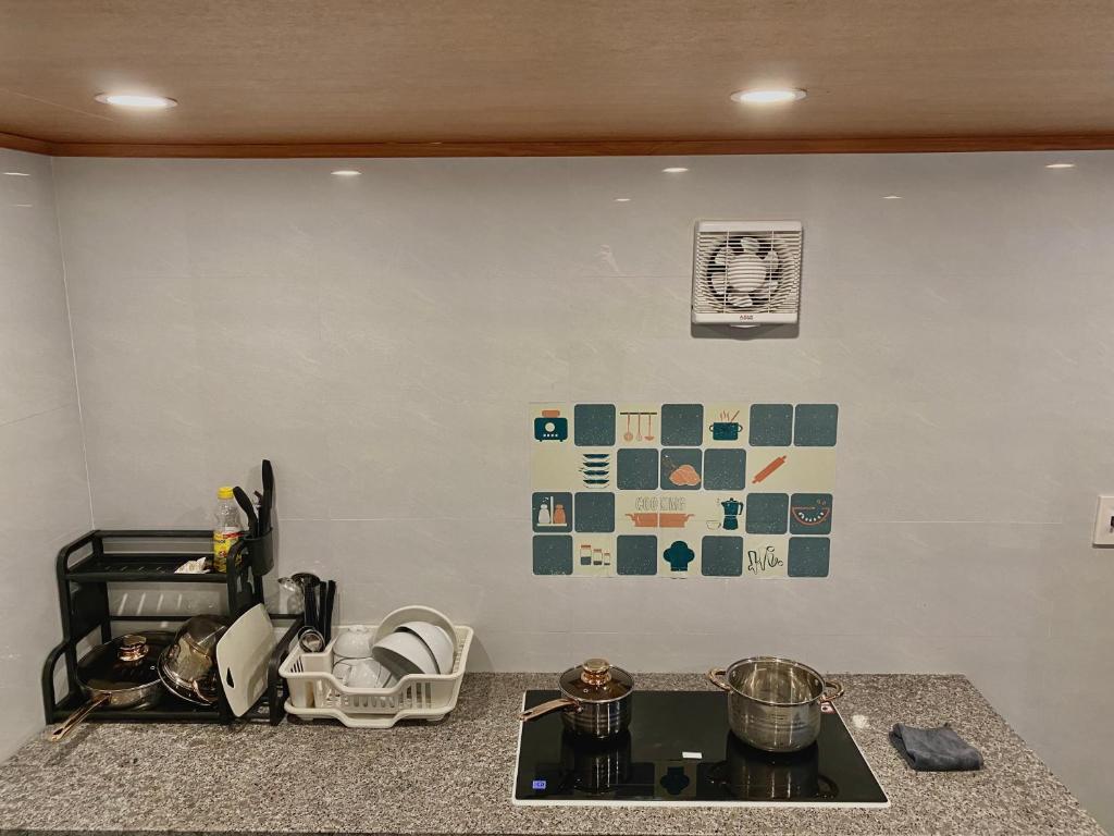 岑山Ngất Ngây Homestay的厨房配有带炉灶和墙壁的台面