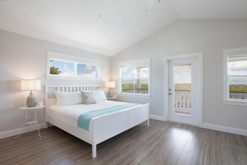 伊斯拉莫拉达Isla Key Kiwi - Waterfront Boutique Resort, Island Paradise, Prime Location的一间白色卧室,配有床和2个窗户