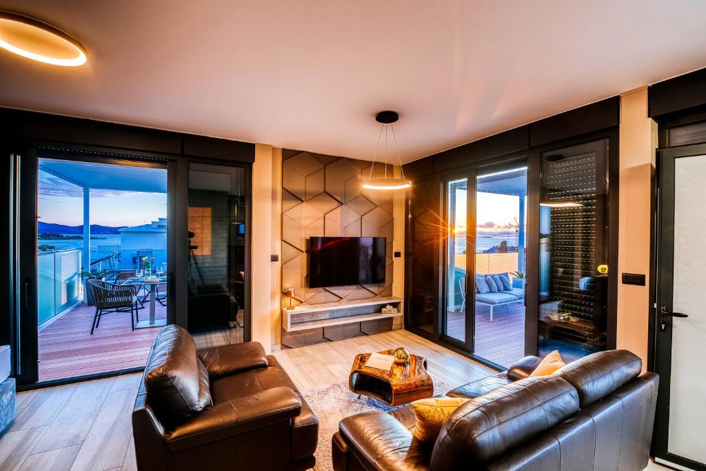 扎达尔Dedaj Resort - Villa Delux的客厅配有皮革家具和电视