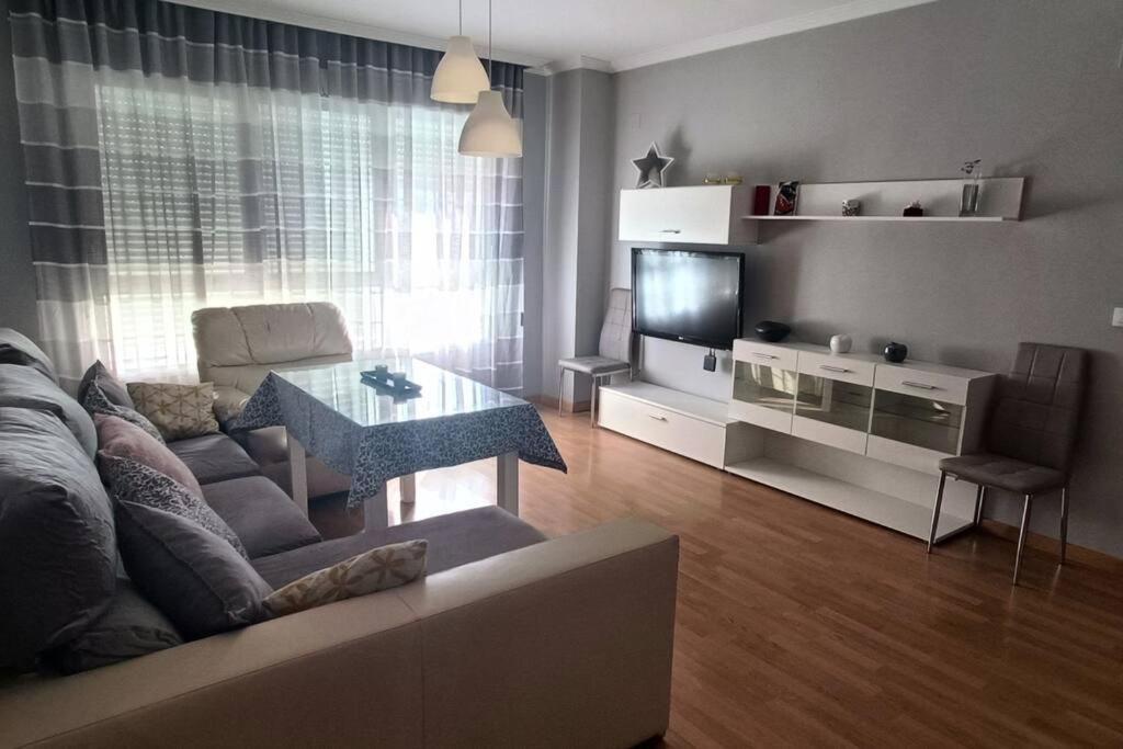 阿尔卡拉拉雷亚尔Apartamento con terraza 2 hab.的带沙发、桌子和电视的客厅