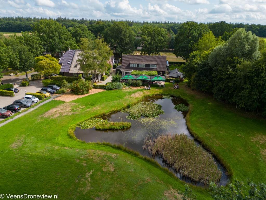 SchoonlooHerberg de Loohoeve的享有高尔夫球场空中美景,设有池塘
