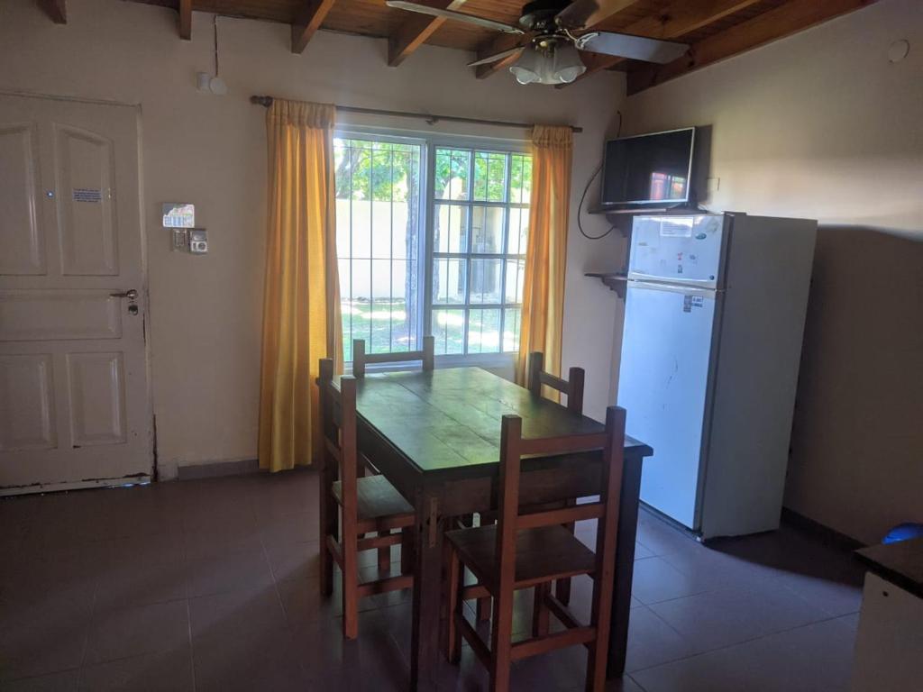 瓜莱瓜伊Bungalows Gualeguay的厨房配有桌椅和冰箱。