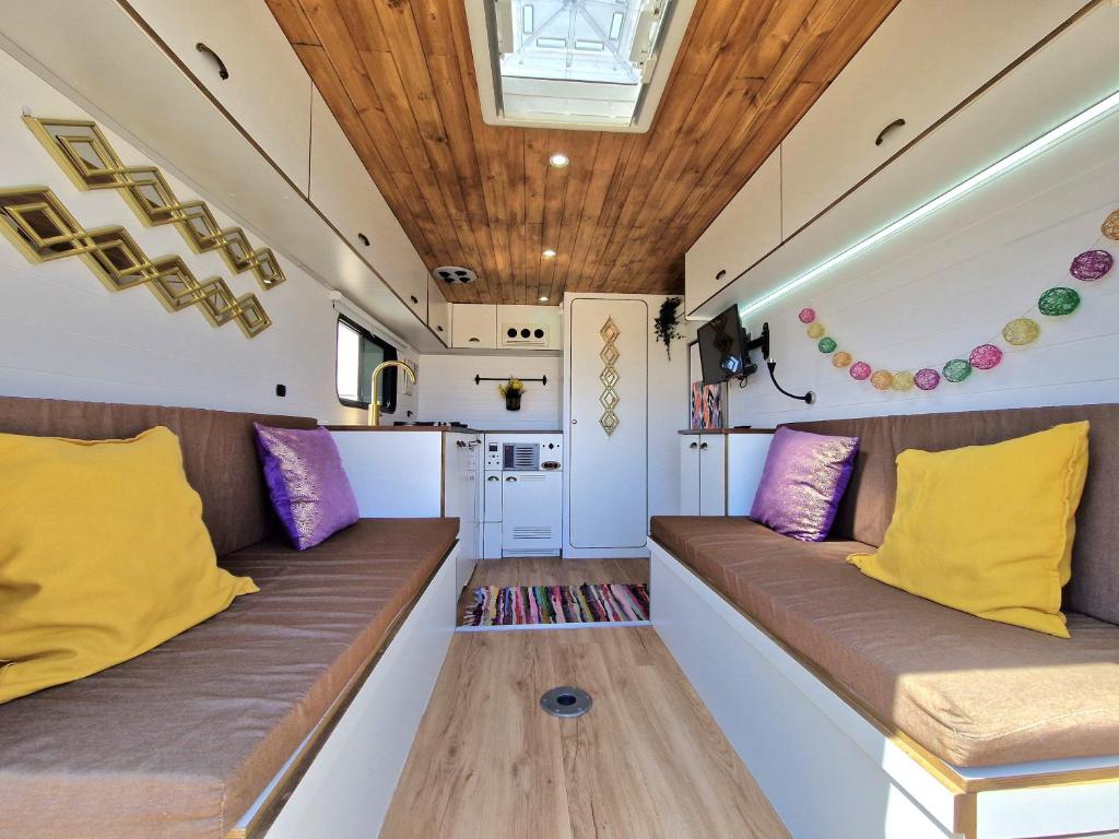 拉特吉塔Camper estatico solo para alojar en el frente del Mar的客厅配有两张带黄色和紫色枕头的沙发