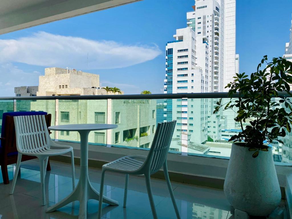 卡塔赫纳Wonderful 2BR with impressive view的阳台配有桌子和两把椅子,设有窗户。
