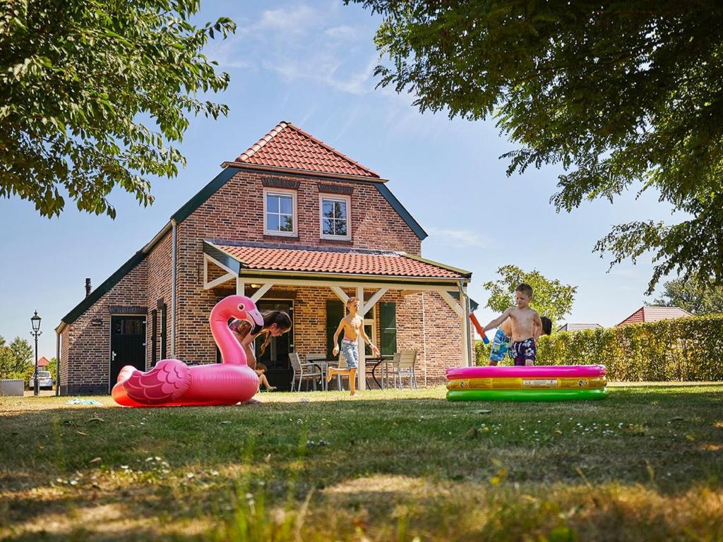 罗赫尔Cozy, child-friendly villa with a sauna in Limburg的一群儿童在房子前玩耍
