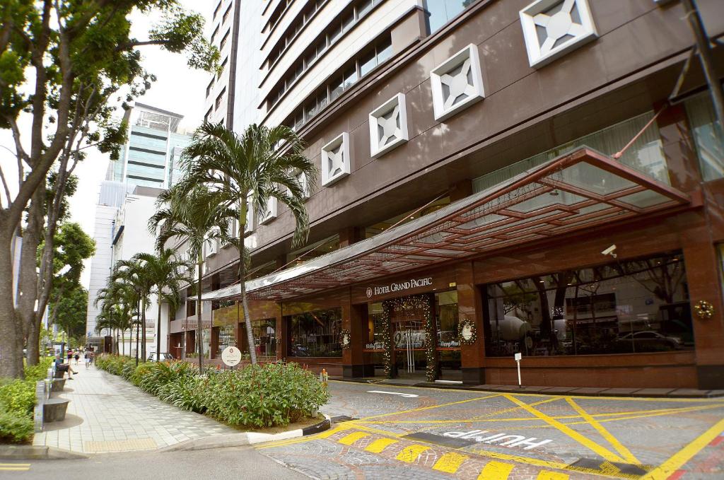 新加坡Hotel Grand Pacific的棕榈树城市街道上的一座建筑
