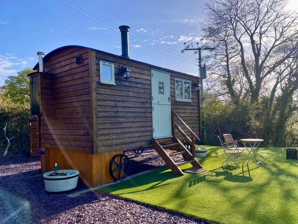 康威Shepherds Hut, Conwy Valley的一个小房子,有楼梯和桌子