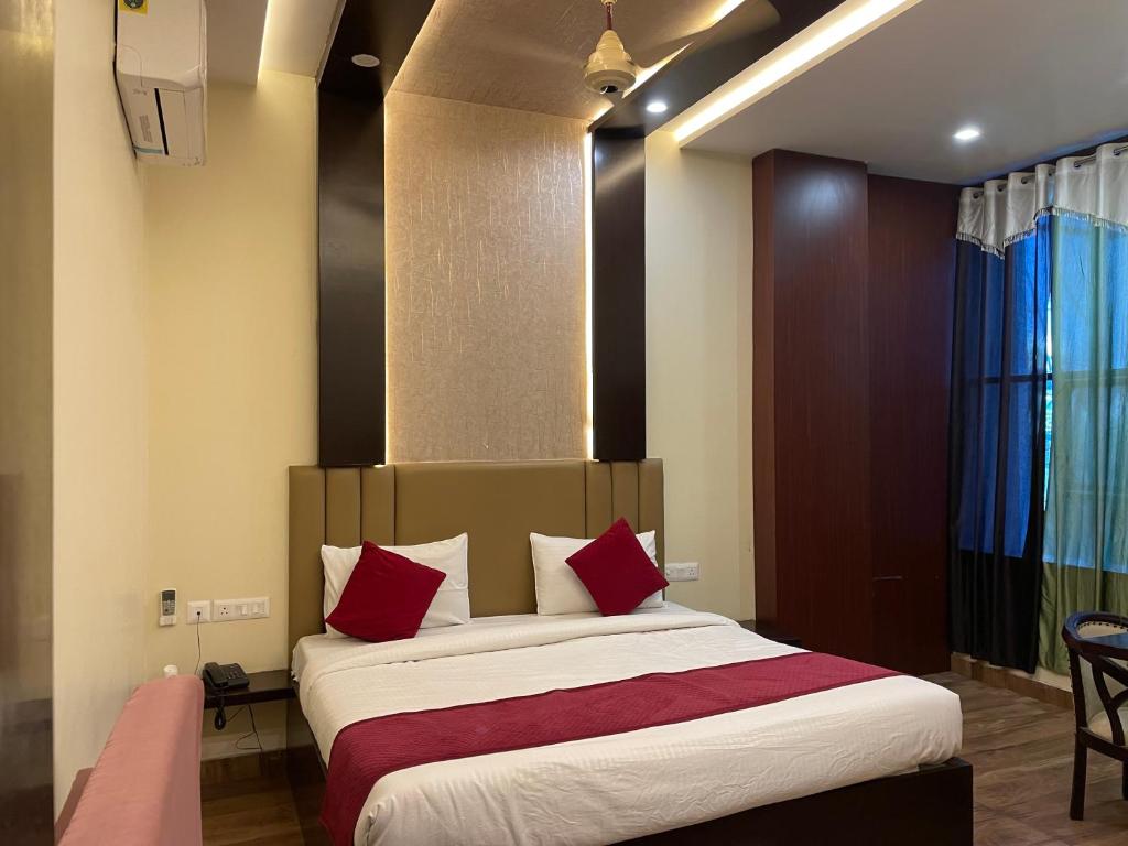 马图拉Hotel City Star Family Stay的一间卧室配有一张带红色枕头的大床