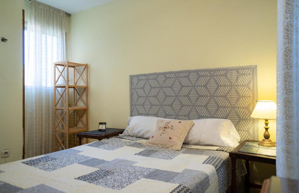 贝纳尔马德纳Habitación doble con baño compartido en Benalmadena的一间卧室配有一张带蓝色和白色被子的床