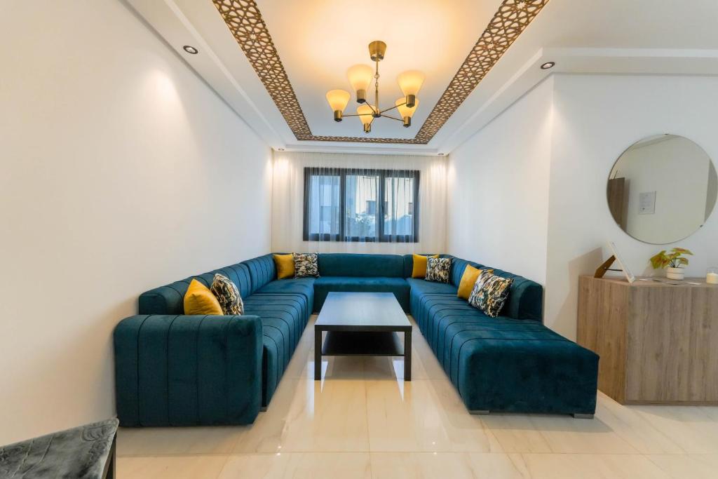 纳祖尔Résidences & Suites Nador的客厅配有蓝色的沙发和桌子