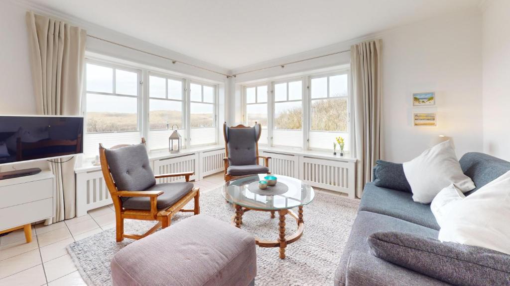 赫尔努姆Haus Weststrand的客厅配有沙发、椅子和电视