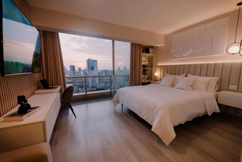 利马Loft Javier Prado的酒店客房设有一张床和一个大窗户