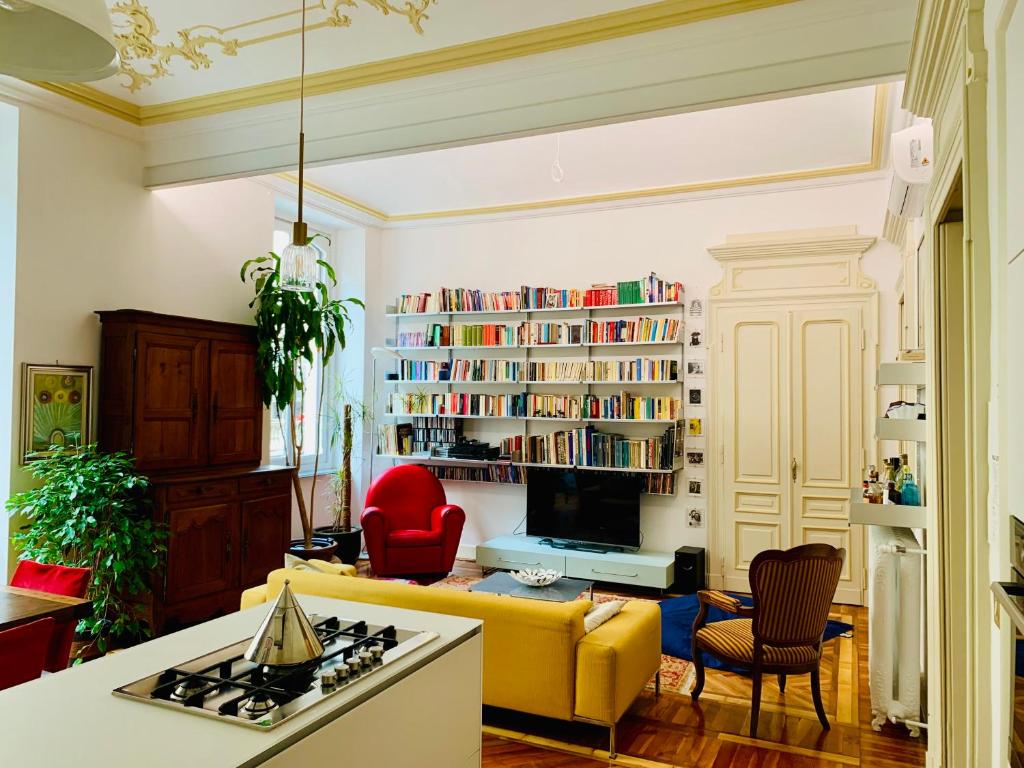 都灵Apart Deluxe Casa Boffa-Costa的客厅设有黄色沙发和书架