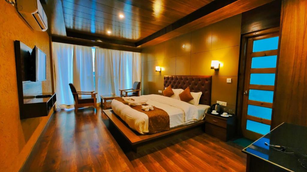 马拉里Vista Resort, Manali - centrally Heated & Air cooled luxury rooms的卧室配有一张床和一张桌子及椅子