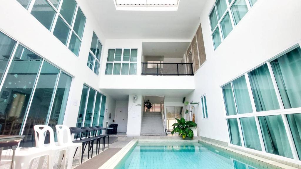 芭堤雅市中心The Inn10 Pool Villa Pattaya, Entire Villa, 9 Bedrooms, Private Indoor Swimming Pool, ดิ อินน์เท็น的一座带窗户的建筑中的室内游泳池