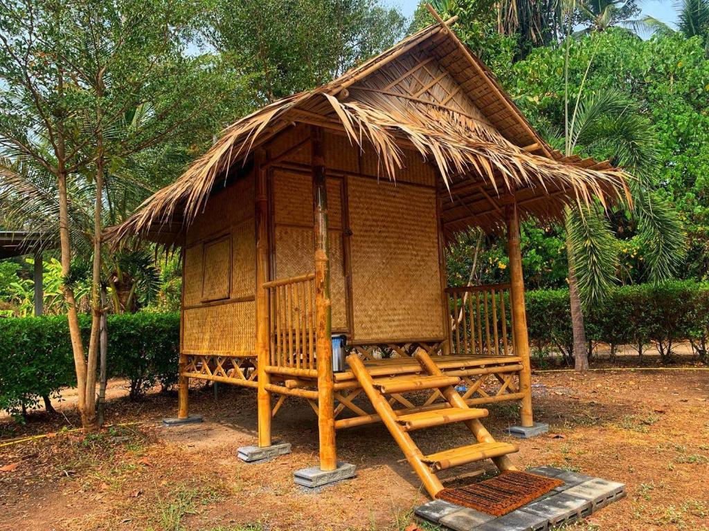 莱姆索塔Samui Camping Farm的茅草屋顶的小小屋和梯子